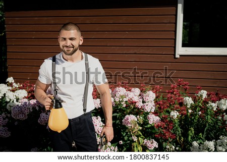 the gardener, a young man working tree. the background trees