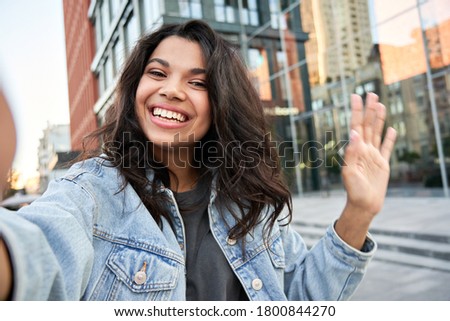 Happy Afro American hipster teen girl blogger influencer recording vlog holding looking at camera. Black woman travel vlogger shooting blog, streaming, video calling on urban city street, headshot. Royalty-Free Stock Photo #1800844270