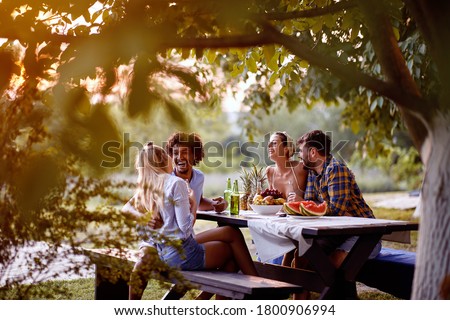 cheerful young friends having  at party outdoor,talking and laughing enjoying at friendship.