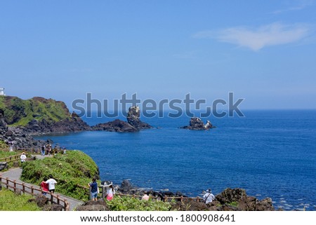stones on the Jejudo costline. calm sea ocean and blue sky background.