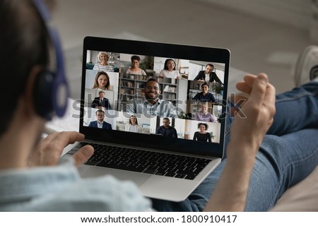 Back view close up of male employee have webcam group digital conference on laptop, engaged in team online meeting, man speak talk on video call on computer from home with diverse colleagues Royalty-Free Stock Photo #1800910417