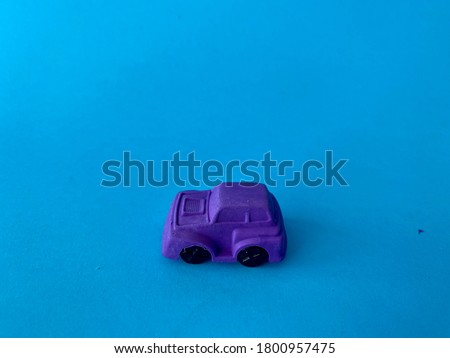 A purple toy car with blue background