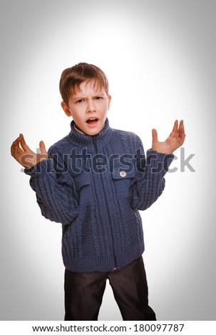 angry teenager boy  unhappy swears, waving his arms isolated on white background gray