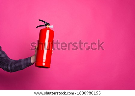 Close up photo of fire extinguisher over pink background with copyspace