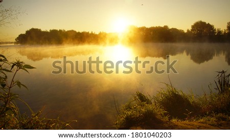 Orange dawn on the river, fog on the water, beautiful summer morning landscape                             