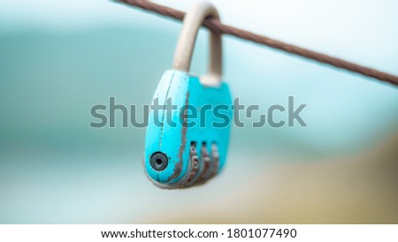 old lock hang on cable with blurry nature background. safety life new normal concept.