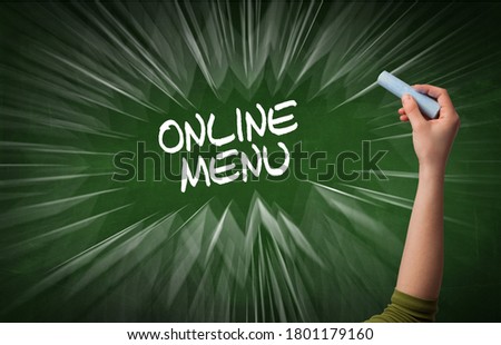 Hand drawing ONLINE MENU inscription with white chalk on blackboard, online shopping concept