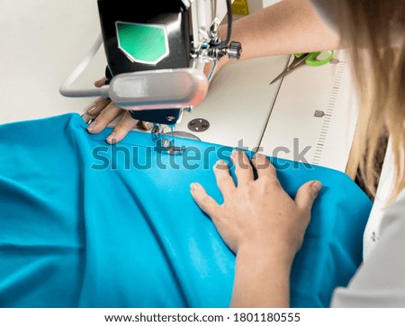 Designer tailor sew the dress. Woman use sewing machine for his work.