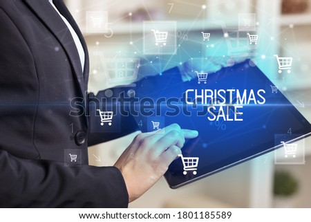 Young person makes a purchase through online shopping application with CHRISTMAS SALE inscription