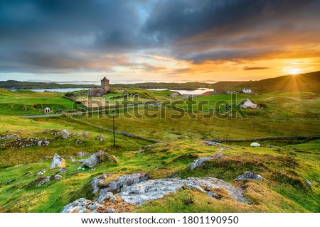 Beautiful sunset over the village of Rodel on the Isle of Harris in the Western Isles of Scotland, with St Clement's Church in the far left Royalty-Free Stock Photo #1801190950