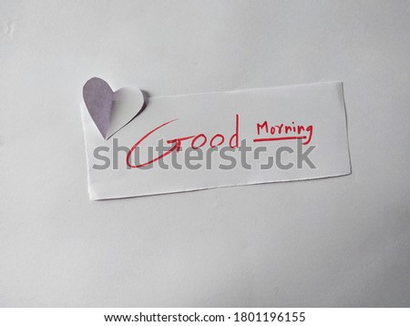 A good morning text message with heart shape on paper.