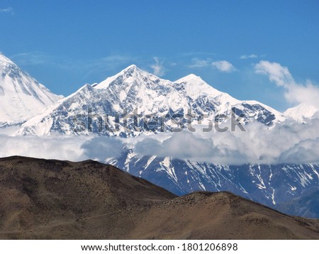 Snow capped Himalayas mountains, Mustang, Nepal. Wonderful Dhaulagiri massif. Dramatic views of  beautiful Himalayan mountains. White haze from clouds  near summit Yakawa Kang. Mountainous landscape.