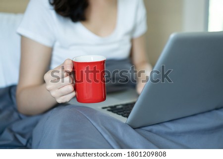 Asian young woman's portrait in working at home concept. Happy Asian woman showing OK sign during using video conference with her friend during stay at home. Joyful woman browsing the internet.