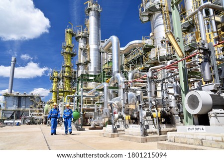 chemical industry plant - workers in work clothes in a refinery with pipes and machinery  Royalty-Free Stock Photo #1801215094