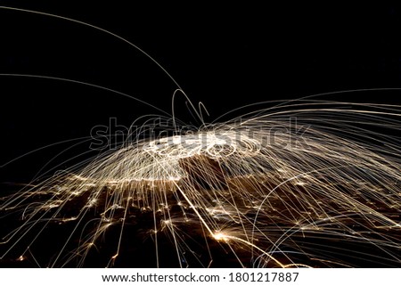 A steel wool on fire at night (night photography using a slow shutter speed) - selective focused on the subject.