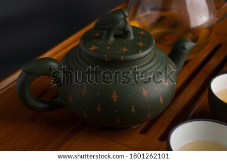 Green traditional chinese Yixin clay teapot with cicada on the cover and accesories for tea ceremony