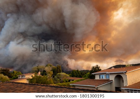 The California "River Fire" of Salinas,  in Monterey County, was ignited by dry lightning on August 16, 2020, fills the sky with dark smoke and flames as it burns close to a houses on its first day.   Royalty-Free Stock Photo #1801300195