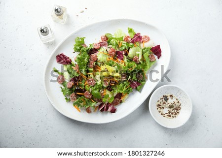 Healthy green salad with salami