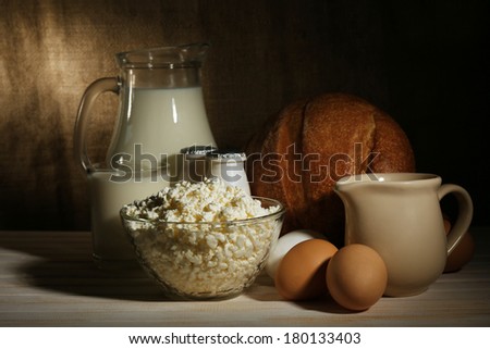 Tasty dairy products on wooden table, on sacking background