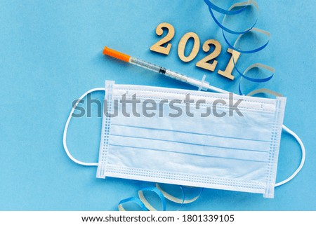disposable hygienic face mask,sanitizer, 2021  christmas and new year decor on blue background. holidays self-isolation and pandemic covid concept 