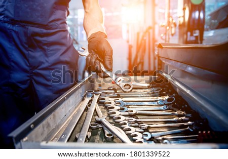 Tools at the hands. Auto repair service Royalty-Free Stock Photo #1801339522
