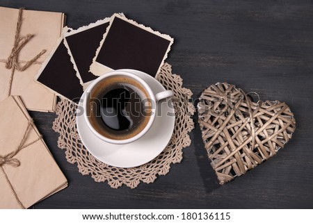 Composition with coffee cup, letters and old blank photos, on wooden background