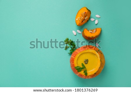 Pumpkin soup in pumpkin on a colored background. Bright colored background with copy space.Healthy food. Pumpkin