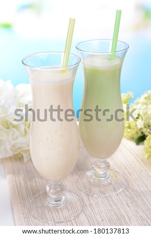 Milk shakes on table on light blue background