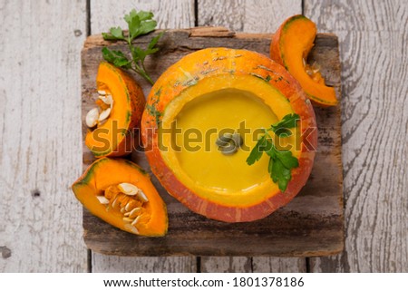 Pumpkin soup in pumpkin on a light wooden table. Healthy eating. Pumpkin. Pumpkin seeds