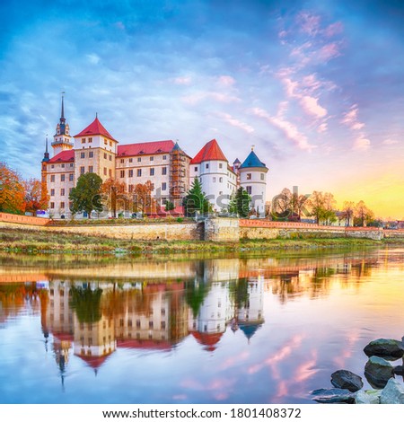 Picturesque morning view of Hartenfels castle on banks of the Elbe. Dramatic sunrise. Location: Torgau, NorthWestern Saxony, Germany, Europe