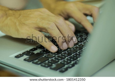 Man hands working on laptop keyboard, closeup shot.