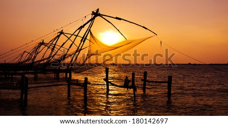 Indian Man Fishing Under The Great Chinese Nets at Cochin, Kerela, India 