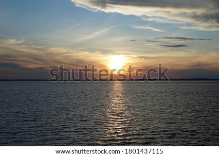 Beautiful sunset on the coast, sunny path in the water, reflection, clouds of various colors, no people, view from the hill, Bernarde Island, Quebec, Canada
