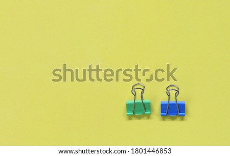 Clamp paper clip on yellow art paper background and have copy space.