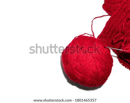 A ball of thread for knitting clothes. White background. Handmade. Burgundy woolen threads for knitting. Background image. Place for your text. Textile industry.