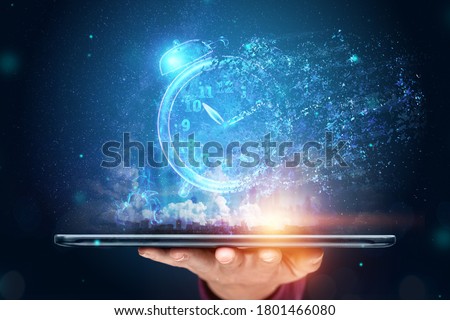 Time management concept, Hand close-up and a tablet with a hologram clock dissolving into air. Time is fleeting, dead line, the passage of time. Copy space