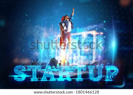 The inscription Startup, Businessman taking off on a Rocket on the background of the image of the charts development strategy, business concept, new technologies, hologram. Copy space