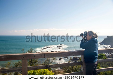 A female photographer shooting from an observation deck in Shimanto City, Shikoku, Japan