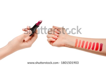 Lipstick swatches on woman hand isolated on white background.