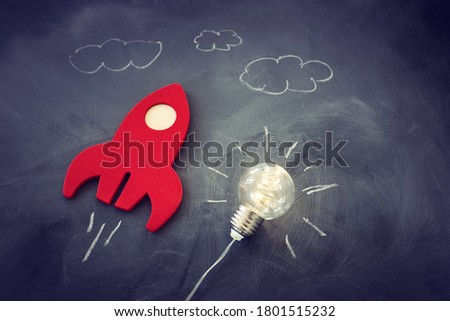 education or innovation concept. Wooden rocket over blackboard background. top view