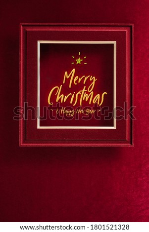 Merry Christmas and happy new year glowing with star in picture frame on velvet red felt fabric wall.winter holiday background