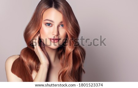 Beauty redhead girl with long  and   shiny wavy red hair .  Beautiful   woman model with curly hairstyle .
