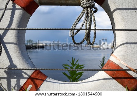 life ring with rope in the middle and a habor in the background photo taken during daytime