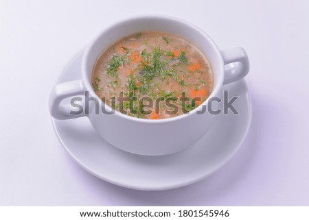A picture of a bowl of traditional chicken soup served in a bowl over white background. Chicken broth for dinner. Delicious healthy meal.