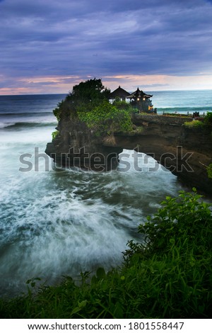 Tanah Lot Bali at Beach of Indonesia. Beautiful sunset at Tanah Lot with wavy motion. Landscape Photography. Royalty-Free Stock Photo #1801558447