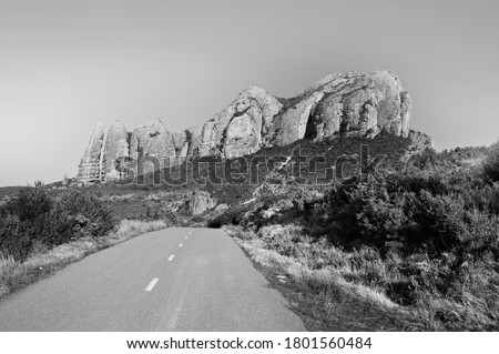 Deserted road in Spain in black and white. Paved narrow path to a canyon in the Spanish Pyrenees.