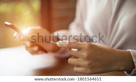Close up and selective focus of a teenage woman hands holding credit card and smart phone make online payment for shopping. Stock photo.