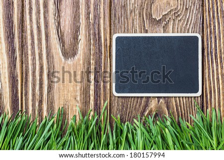 blackboard and green grass on a background of the fence