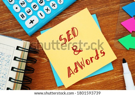 Business concept about SEO&AdWords with sign on the piece of paper.