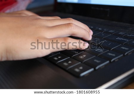 Close up of boy fingers typing on a computer keyboard